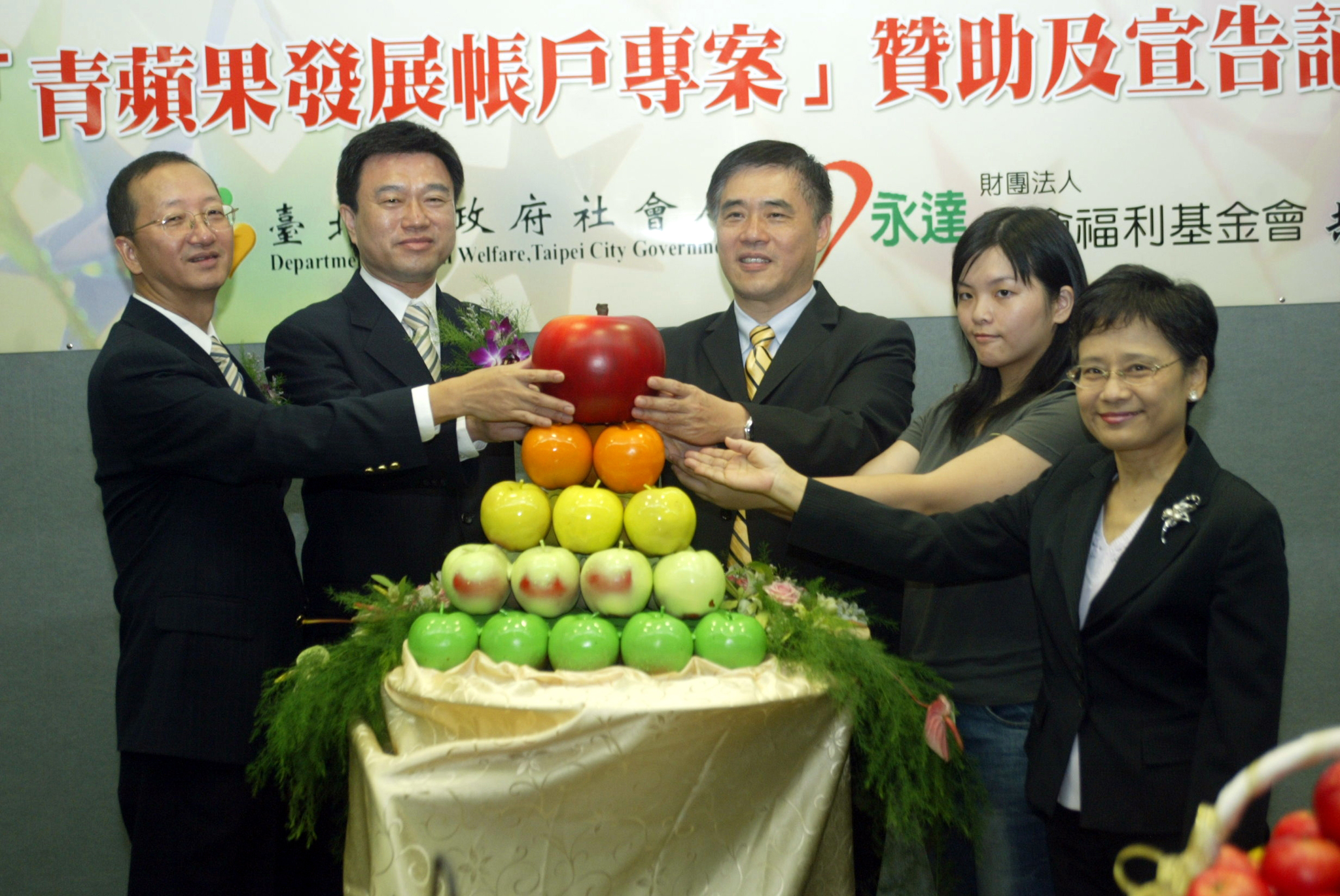 青蘋果發展帳戶記者會~圓夢儀式(左一依序永達保經黃總、永達保經暨基金會吳董事長、郝市長、低收入戶代表、師局長)。