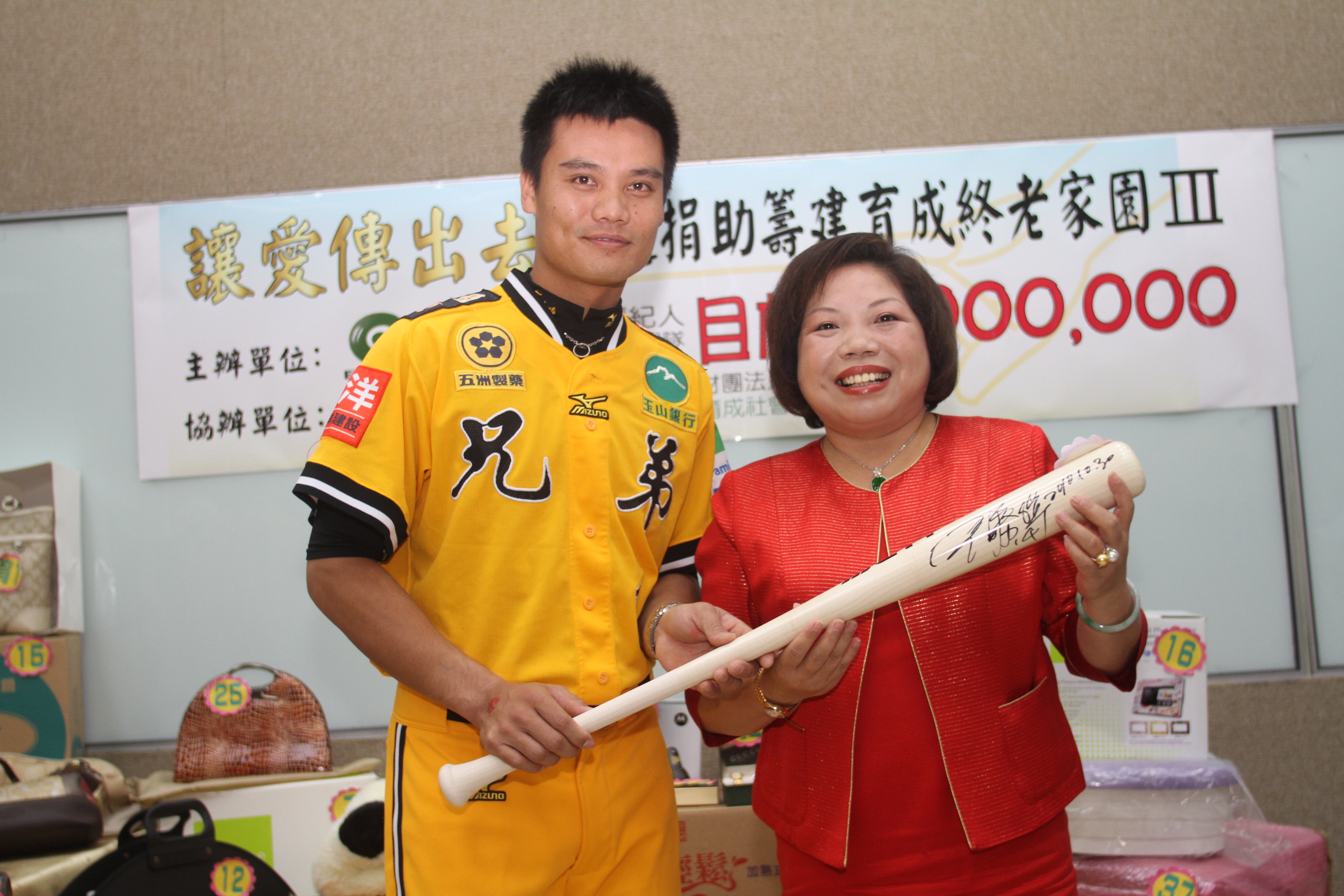 永達黃素英副總(右)高價標下兄弟象王勝偉(左)提供的專屬貼身練習球棒。
