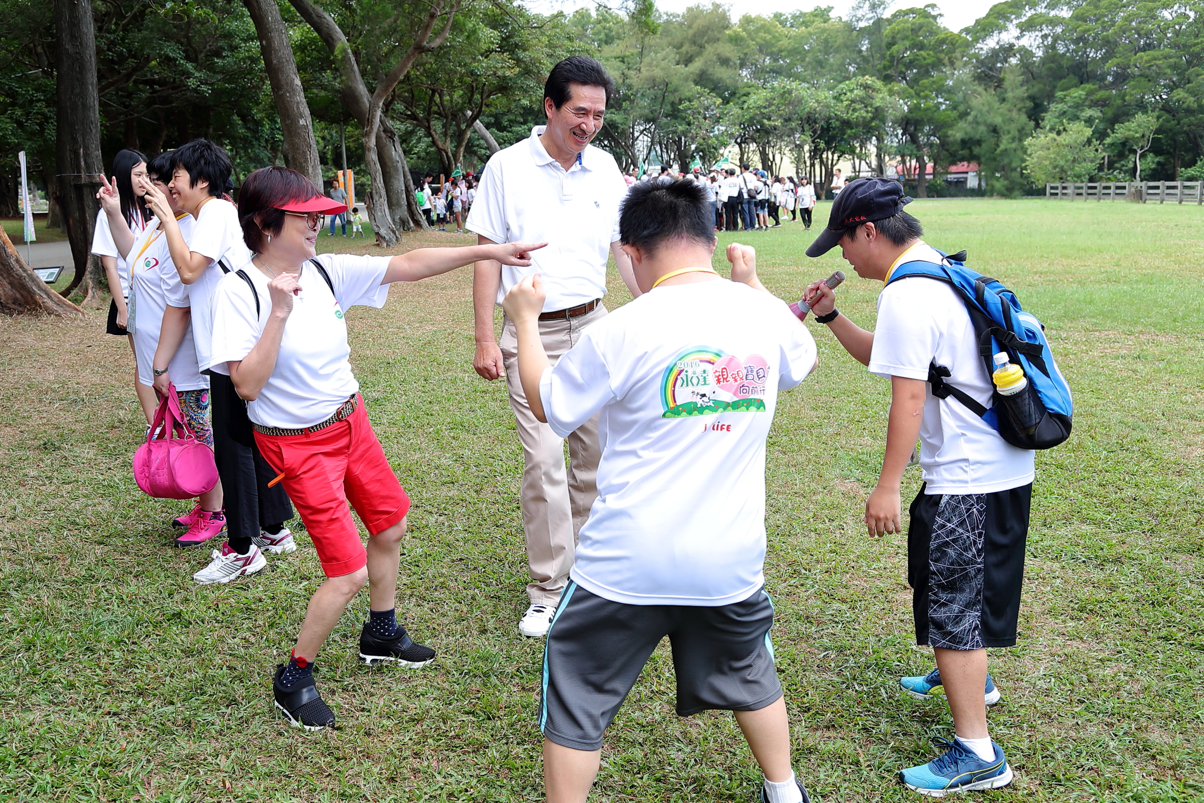 (左一)台灣優質生命協會紀寶如秘書長、永達保經陳慶鴻總經理與可愛的憨兒寶貝愉快的在草皮上嬉戲。