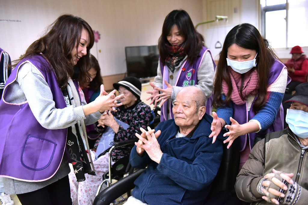 志工們帶動長輩做暖身運動。