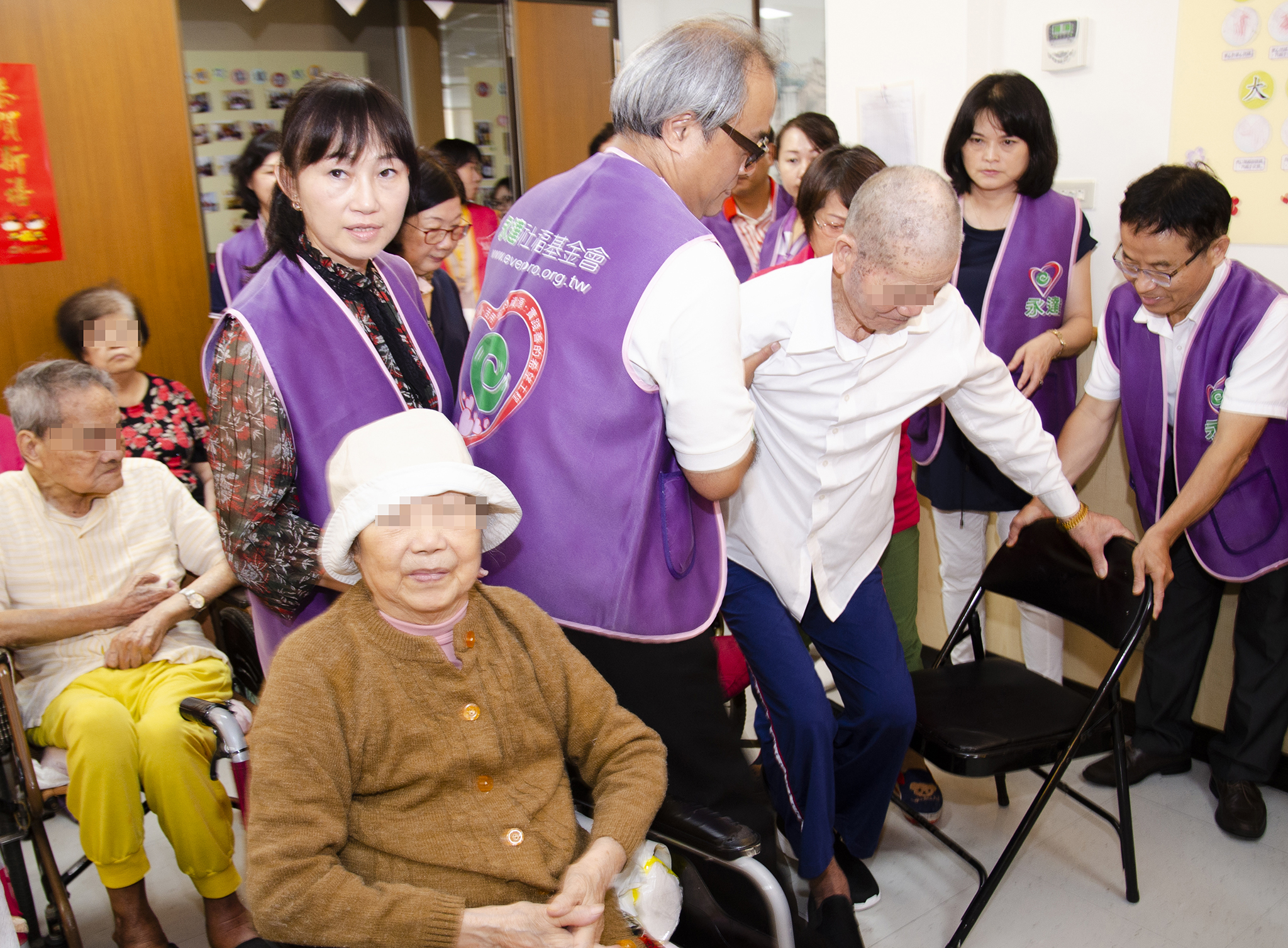 永達志工熱心協助行動不便長輩入坐。