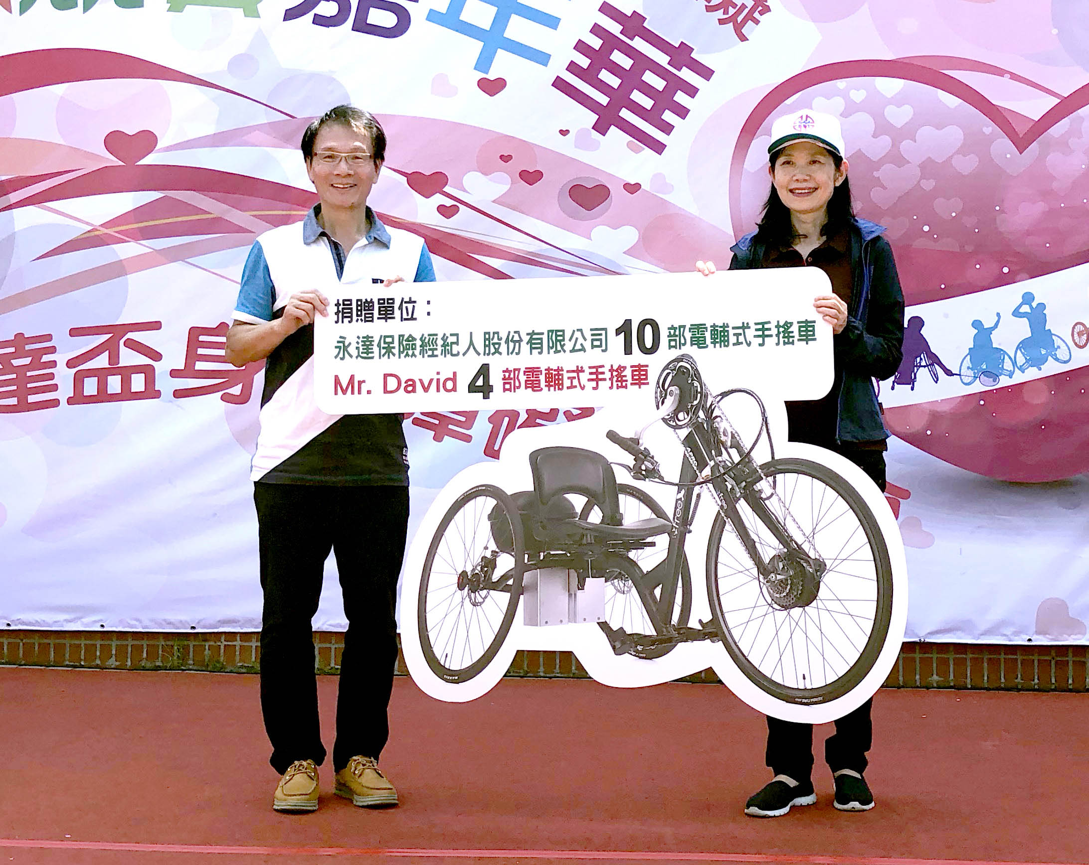永達保經李忠約副總(圖左)代表捐贈10輛電輔式手搖自行車,由新北市呂衛青副市長(圖右)代表受贈。