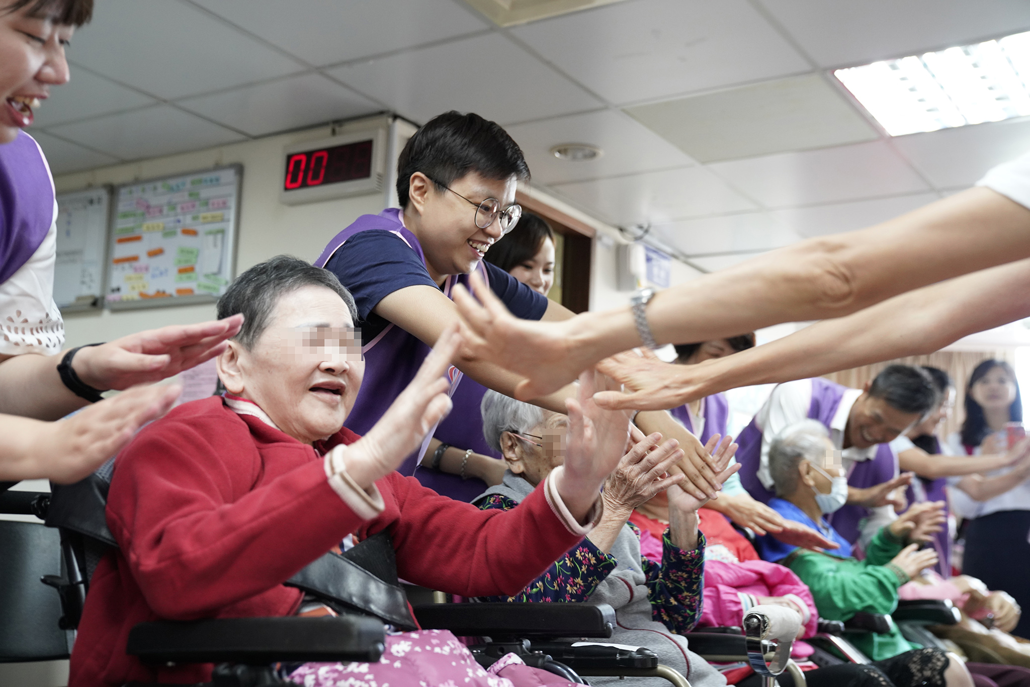 永達志工與爺爺奶奶擊掌、牽手，透過手心的溫度傳遞關心與能量。