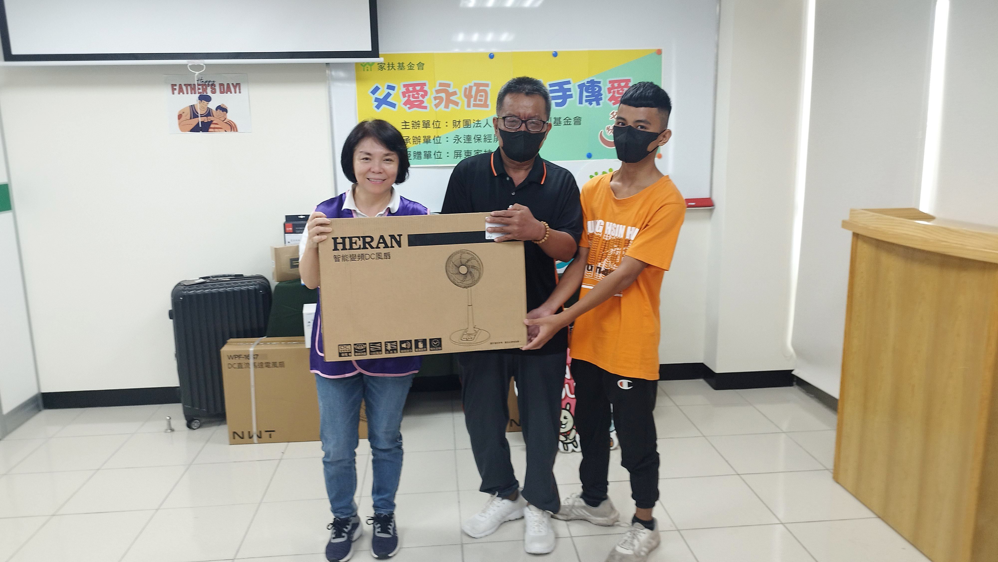 單親家庭的小齊(右),父親(中)以臨時工獨自拉拔六個孩子長大,礙於鐵皮屋頂的家中空間有限,父親獨自睡在客廳沙發上,近年因車禍等諸多身體不適,加上每到夏天炎熱難耐,小齊及手足們希望能買一台電風扇,讓父親能夠有更舒適的生活空間,不再受炎熱的天氣所苦,感謝永達黃如翊業務籌備協理(左)代表致贈。