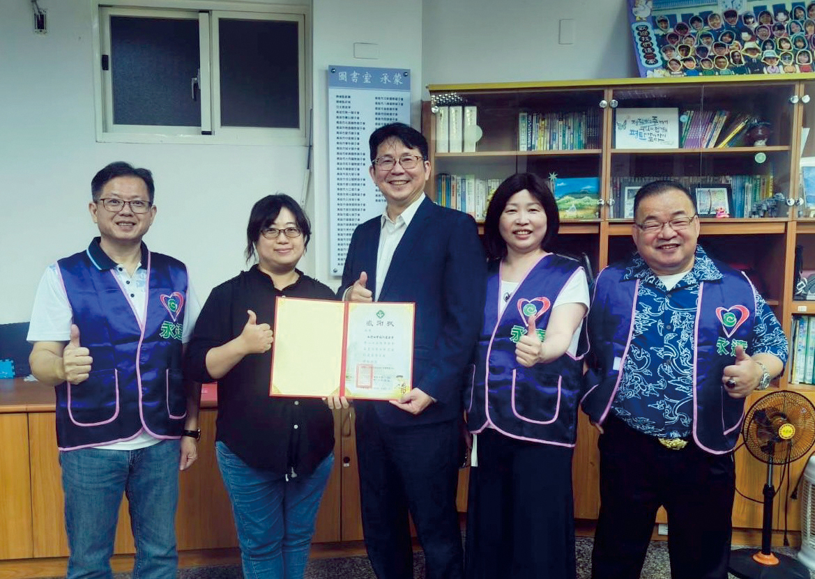 高雄市紅十字會育幼中心林瑛凰院長(左2)頒贈感謝狀,由永達保經高文山業務副總(中)代表受贈,與陳慧雯業務籌備副總(右2)、蔡明宏業務協理(左1)、張富強業務籌備協理(右1)合影留念。